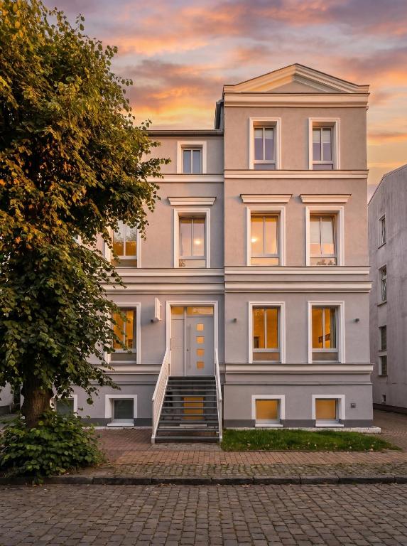 ein Wohnhaus in der Stadt bei Sonnenuntergang in der Unterkunft LIGHTHOUSE APPARTEMENTS - Premium Ferienwohnungen in ruhiger, zentraler Lage in Warnemünde