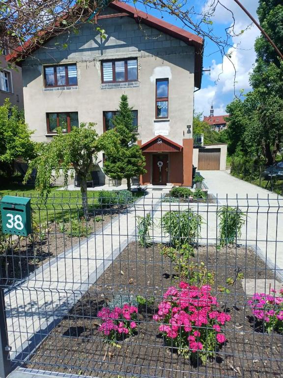 a house with pink flowers in front of a fence at ivlo in Pszczyna