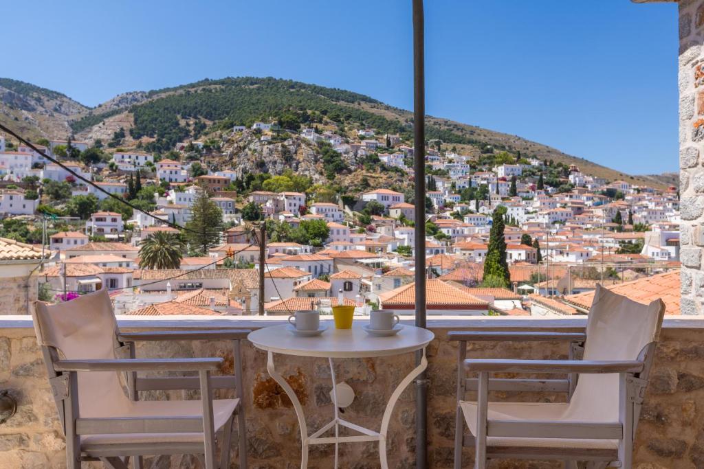 a table and chairs on a balcony with a view at Gaia accommodation Hydras in Hydra
