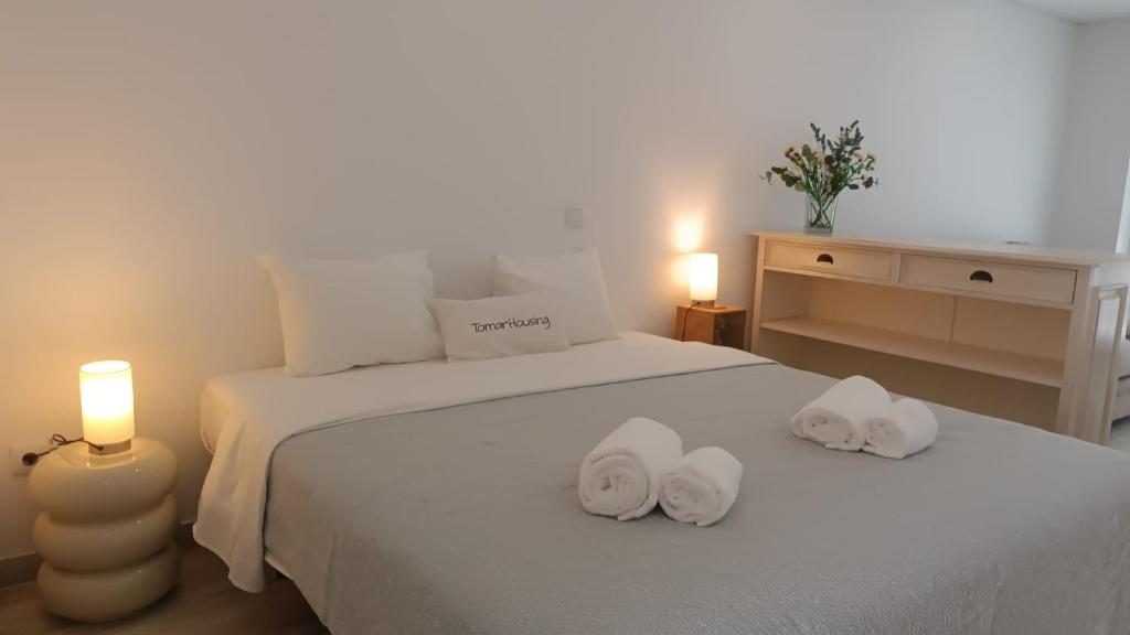 a bedroom with two towels on a bed with two candles at Tomarhousing - Secret Garden in Tomar