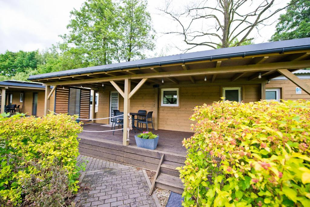 a house with a wooden porch with a patio at MOLO RESORT KEMPING in Osiek