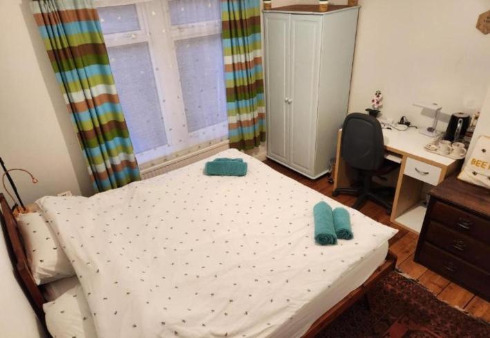 a bedroom with a bed and a desk and a window at BEE HAPPY available with shared bathroom in Glastonbury