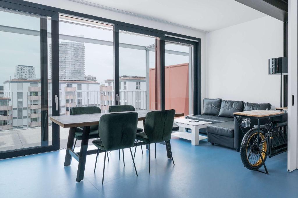 a living room with a table and chairs and a couch at Modern Zurich Apt with Balcony View & Workspace in Zurich