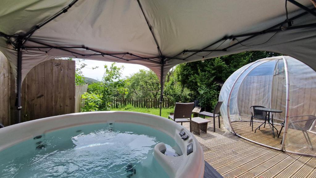 a hot tub in a tent on a deck at The Nook - Farm Park Stay with Hot Tub & Dome in Swansea