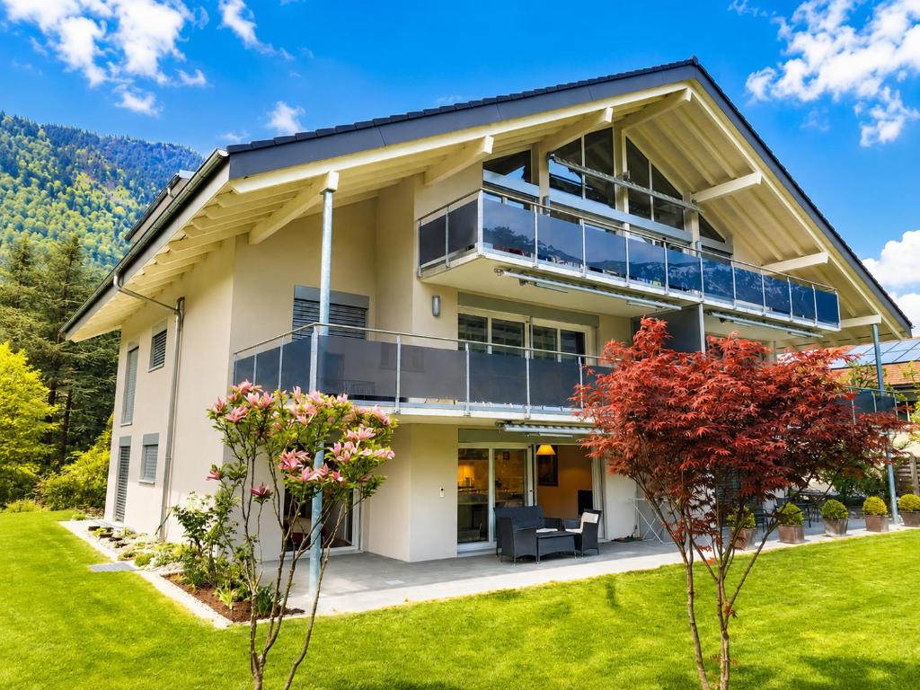 a house with balconies and a lawn at Skender's Apartment in Interlaken