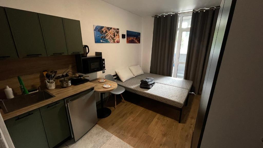 a small kitchen with a table and a microwave at Нові апартаменти 2 поверх, поруч лікарня та парк Феофанія, МХП in Kyiv