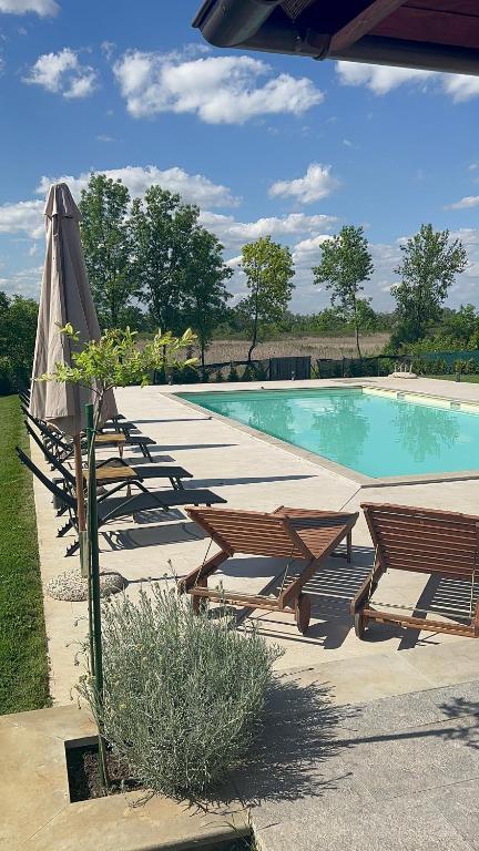 a row of tables and an umbrella next to a swimming pool at Hedona227 in Perlez