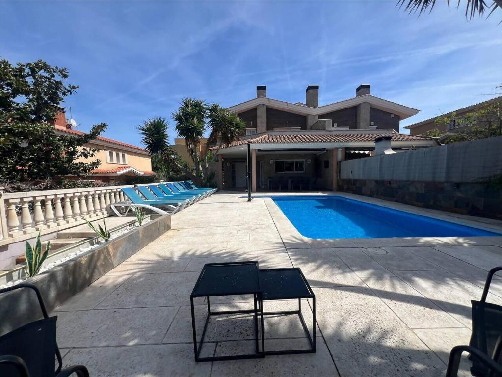 a swimming pool in front of a house at Villa Castelló Salou (cerca Port Aventura) in Salou