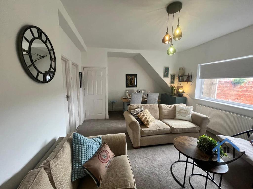 a living room with a couch and a clock on the wall at 28 Victoria Terrace, Bedlington, ground floor in Bedlington