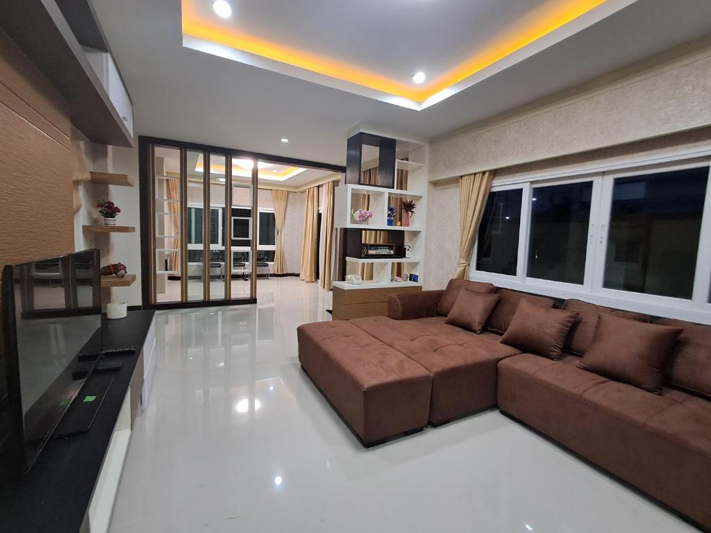 a living room with a brown couch in a room at Minie House Hatyai in Hat Yai