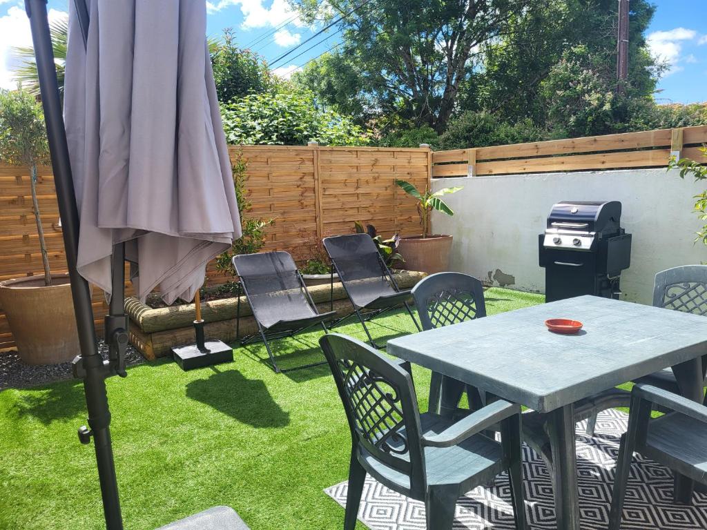 a patio with a table and chairs and an umbrella at Studio Cosy in Saint-Lon-les-Mines