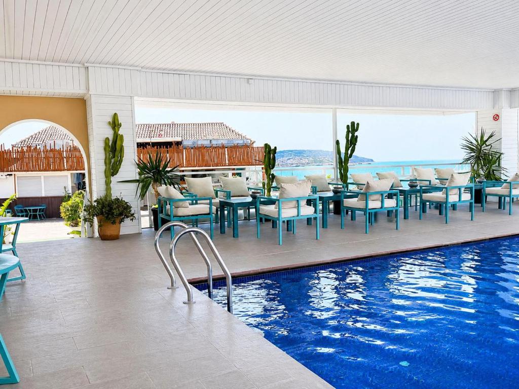 a swimming pool with tables and chairs in a building at Mandarin Hotel & Spa Tanger in Tangier