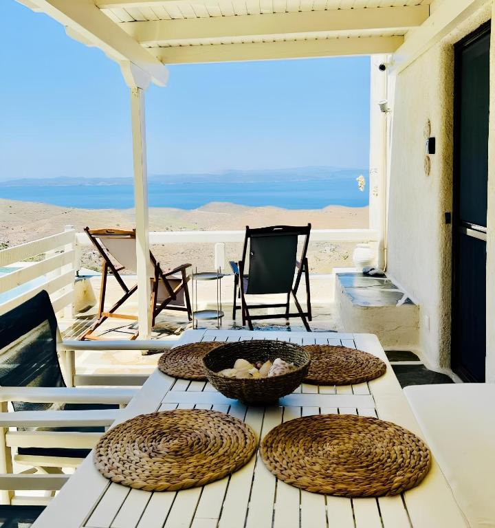 a table with four plates on it with a view of the beach at Pasithea Sunset in Milopótamos