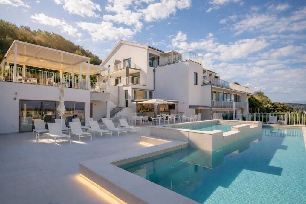 a villa with a swimming pool and a house at Zlatni Zalaz,Apartments,Supetarska Draga in Supetarska Draga