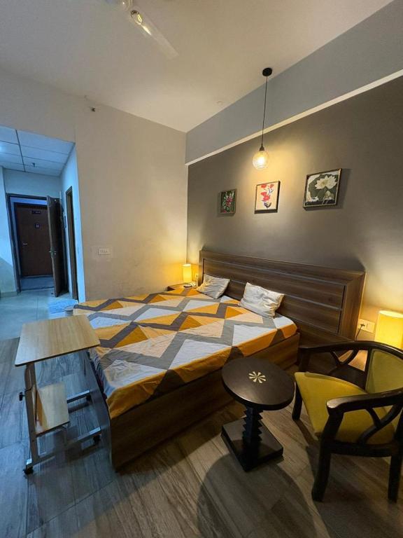 a bedroom with a large bed and a chair at Cozy Crib Stays in Greater Noida