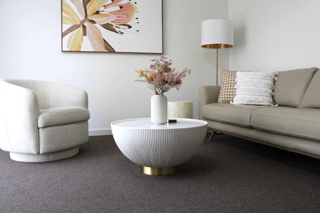 a living room with a couch and a table with a vase at Sunbury on the Park in Sunbury