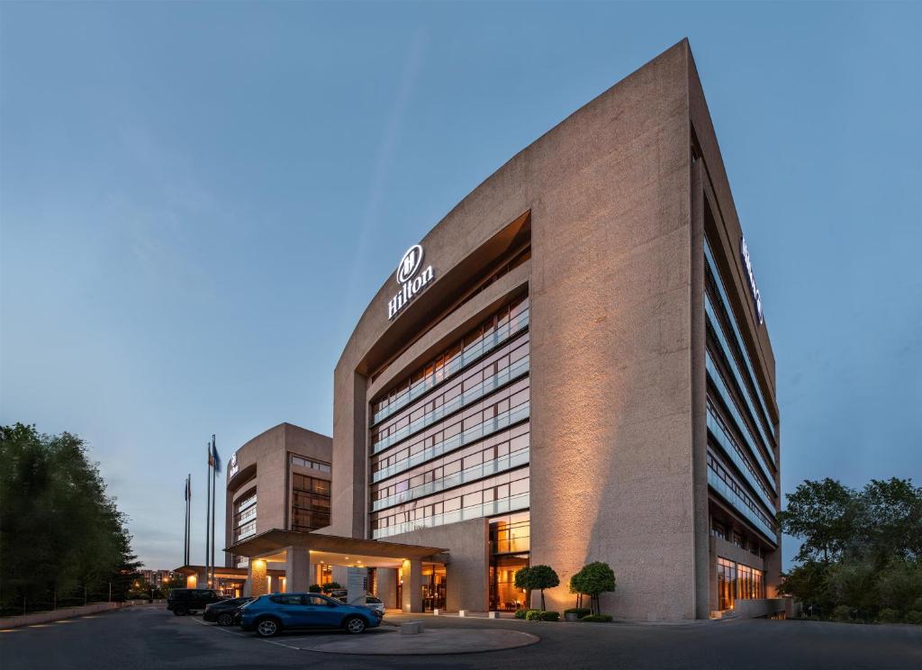a building with a car parked in front of it at Hilton Madrid Airport in Madrid