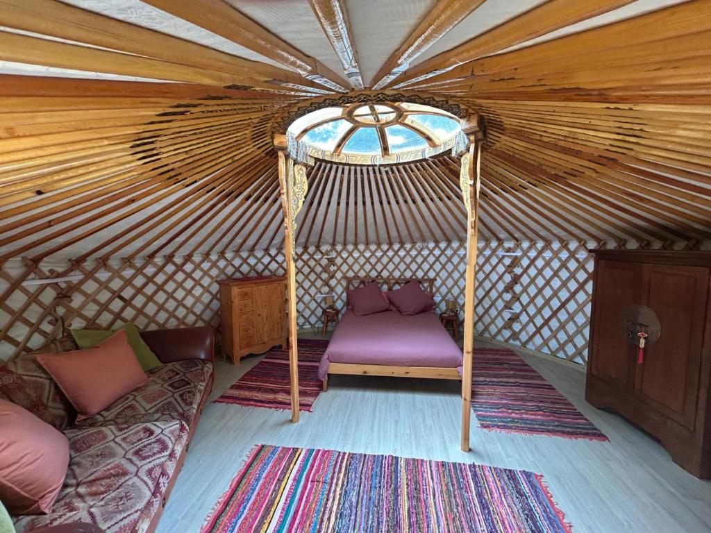 a yurt with a purple chair and couch in it at The yurt at Gites 474 in Sallèles-dʼAude