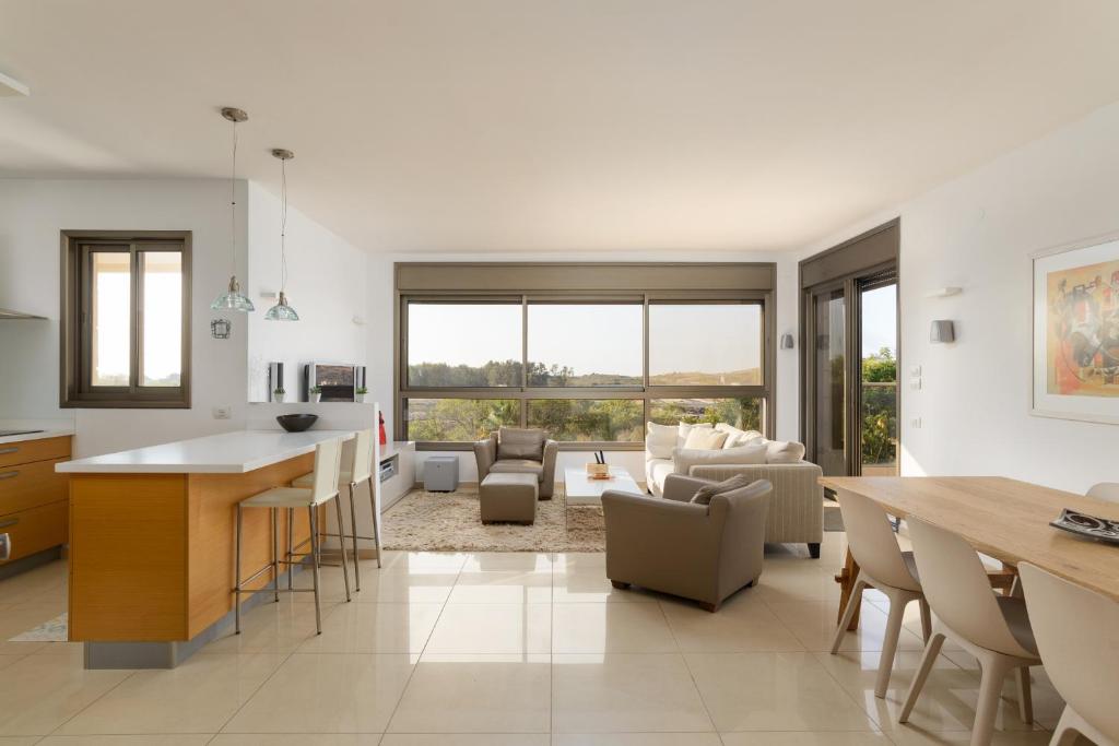 a kitchen and living room with a table and chairs at Mamad Comfort & Terrace In Ramat Aviv By Feelhome in Tel Aviv