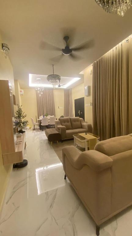 a living room with couches and a ceiling fan at Homestay ZASS in Arau