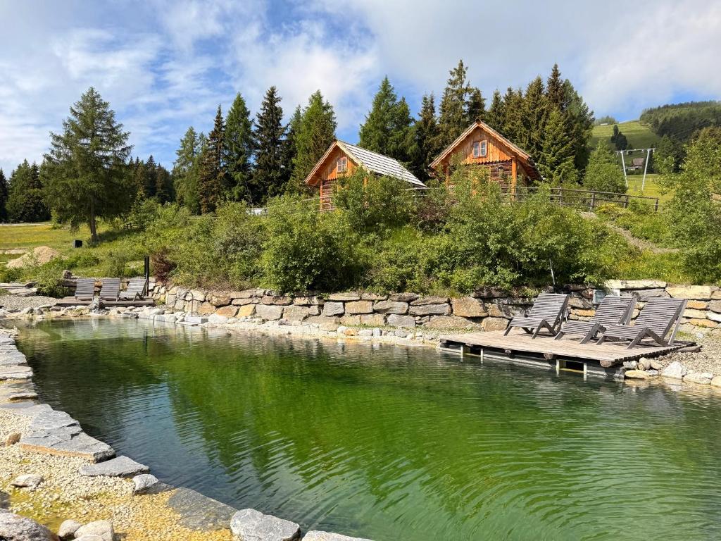 a group of chairs sitting on a dock in a river at Chaletdorf-Fanningberg in Weisspriach