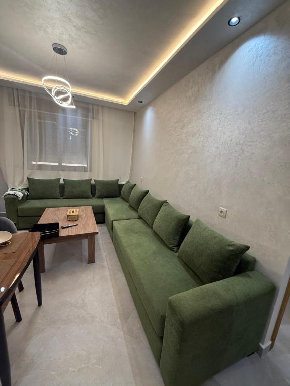 a living room with a green couch and a table at اقامة هبة 3 in Yebha