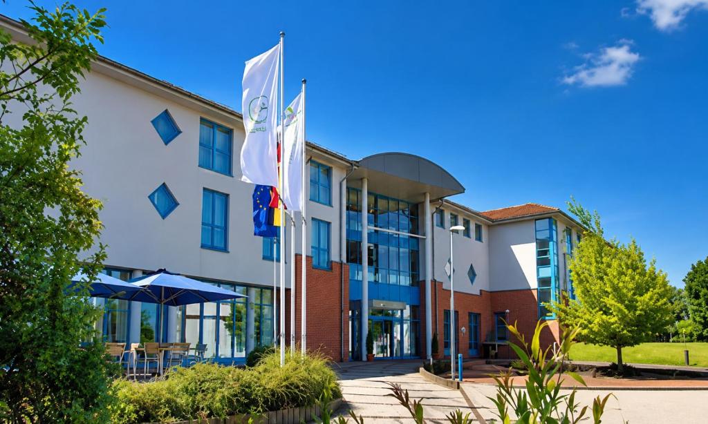 a building with flags in front of it at Sunday Hotel and Spa Wismar in Wismar