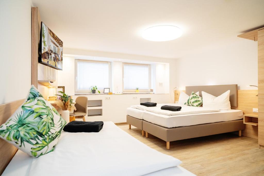 two beds in a room with two windows at Monteurzimmer in Nordhausen