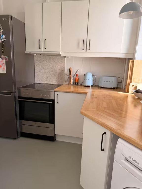 a kitchen with white cabinets and a black refrigerator at Hearthstone Atelier in Antwerp