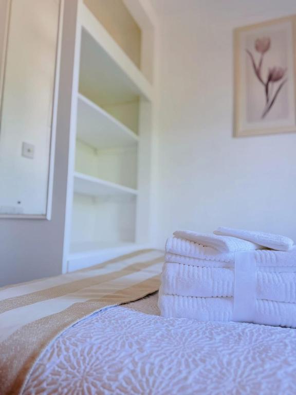 a stack of towels sitting on top of a bed at Le Havre, de joie in Alger
