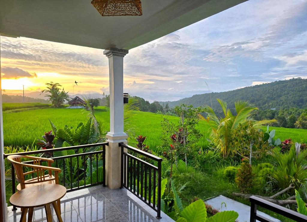 a porch with a view of a green field at Umaku Bali Homestay in Munduk