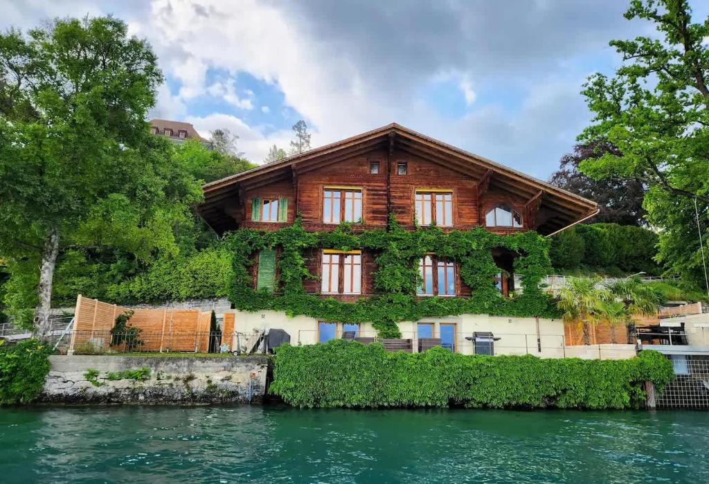a house on an island in the water at Villa Alti Ländte in Oberhofen am Thunersee