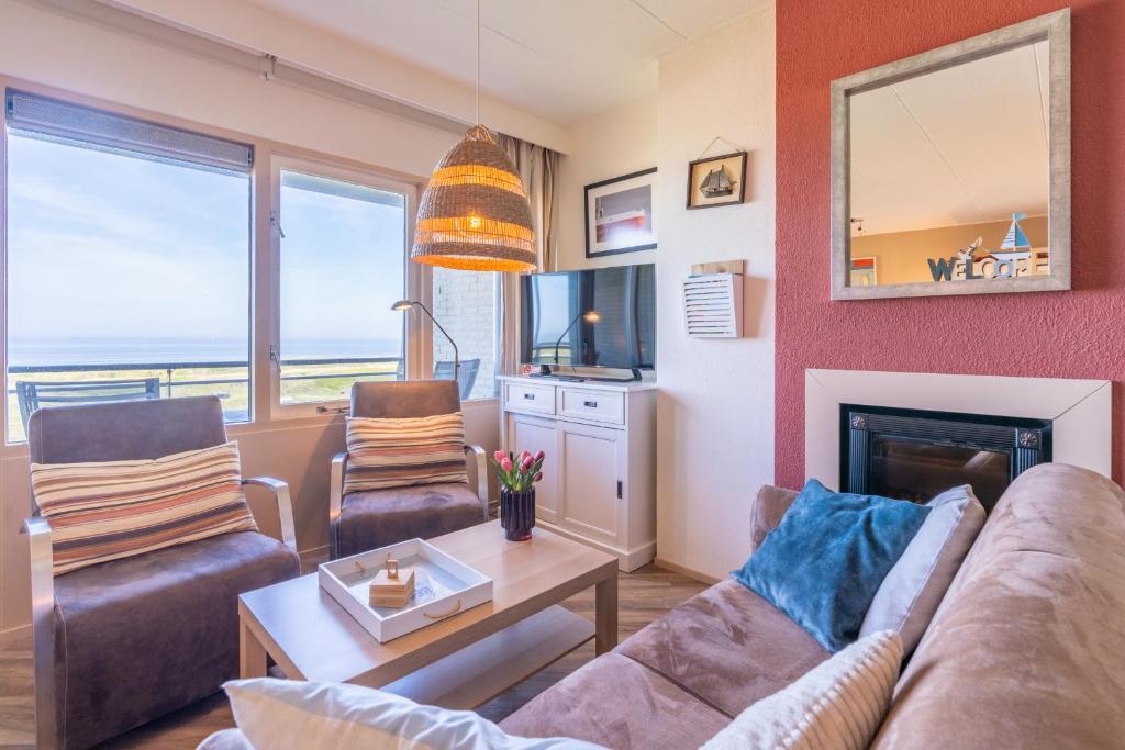 a living room with a couch and a fireplace at Appartementencomplex Juliana 158 in De Koog