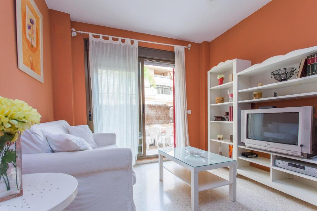 un salon avec un canapé blanc et une télévision dans l'établissement Apartamento Centro Jerez, à Jerez de la Frontera