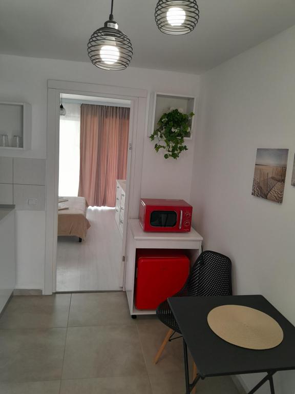 a small kitchen with a table and a red microwave at Garsoniera Serena in Saturn
