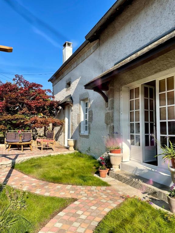 a house with a patio and a porch at charmante maison dans le Morvan in Lormes