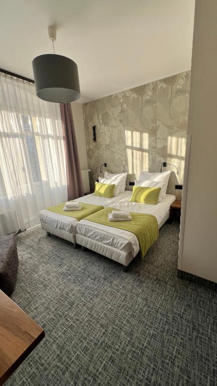 a bedroom with two beds with yellow and white pillows at Willa Na Cichej in Szklarska Poręba