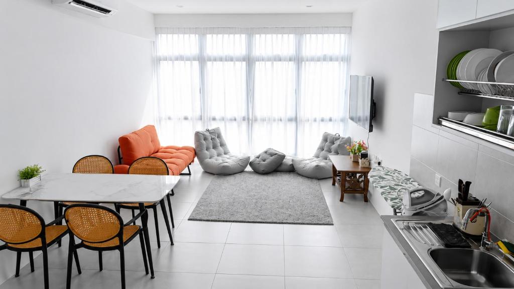 a kitchen with a living room with a table and chairs at d 'ATHIF Homestay Samarahan 2 in Kuching