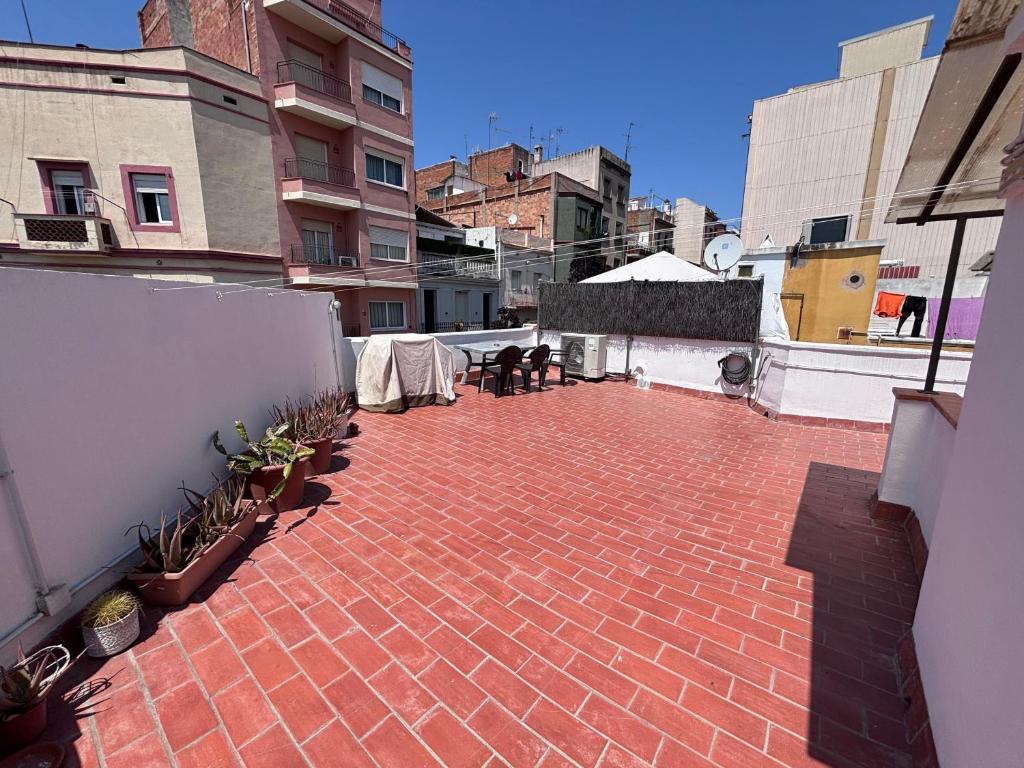 a brick patio with tables and chairs on a building at Private Terrace House near Camp Nou in Hospitalet de Llobregat