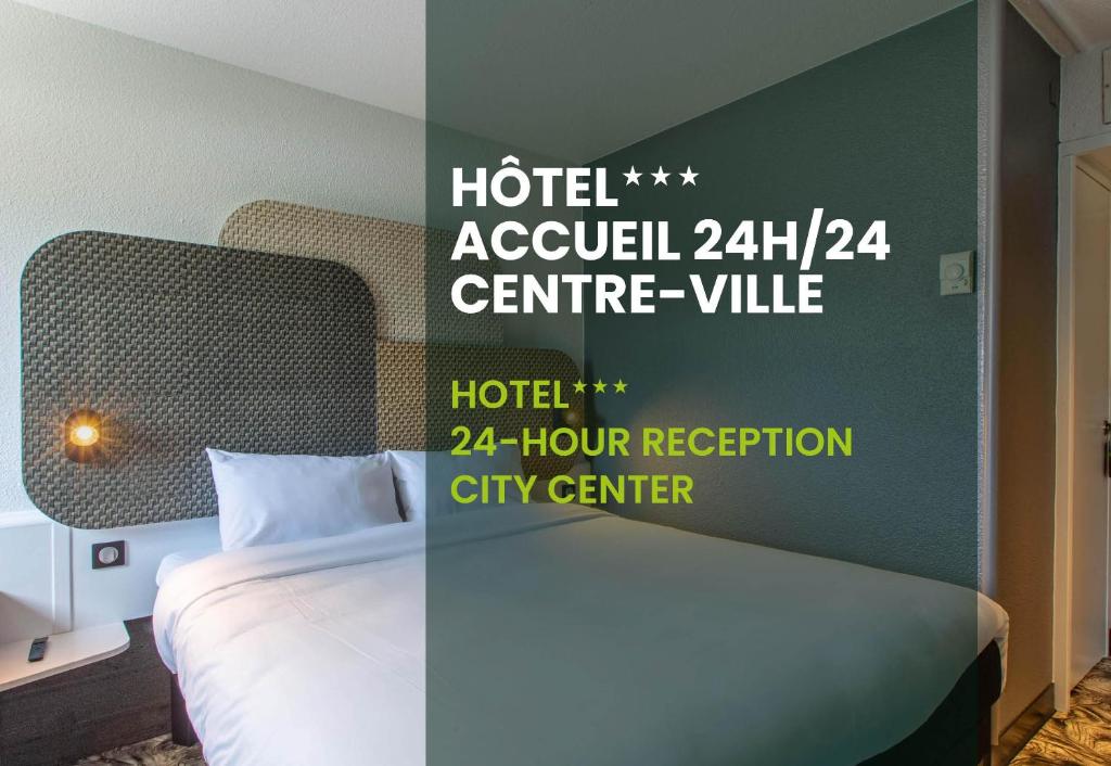 a hotel room with a bed and a sign on the wall at B&B HOTEL Chartres Centre Cathédrale 3 étoiles in Chartres