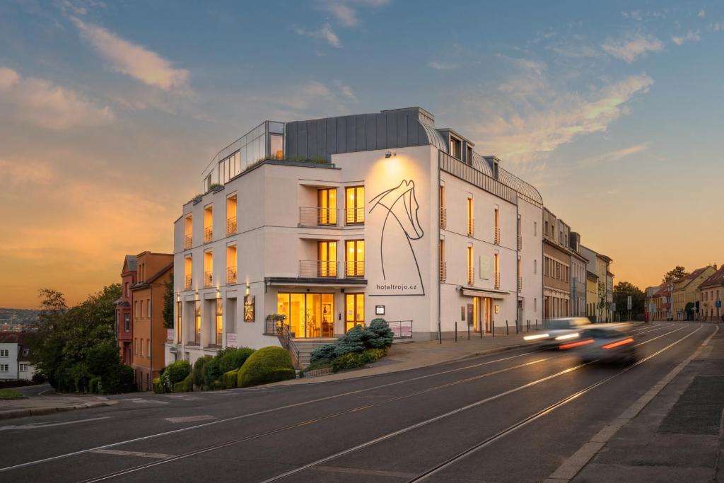 ein weißes Gebäude an einer Straßenseite in der Unterkunft Hotel Troja in Prag