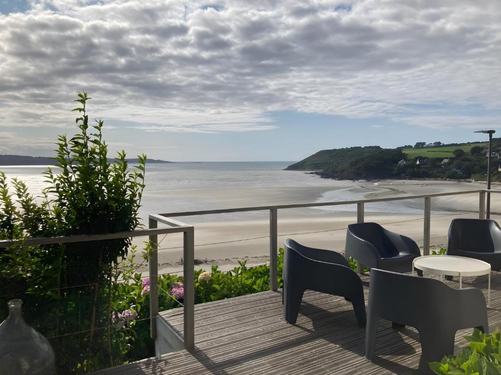 a balcony with chairs and a view of the beach at Maison Ty Bastian, 100 M² in Saint-Michel-en-Grève