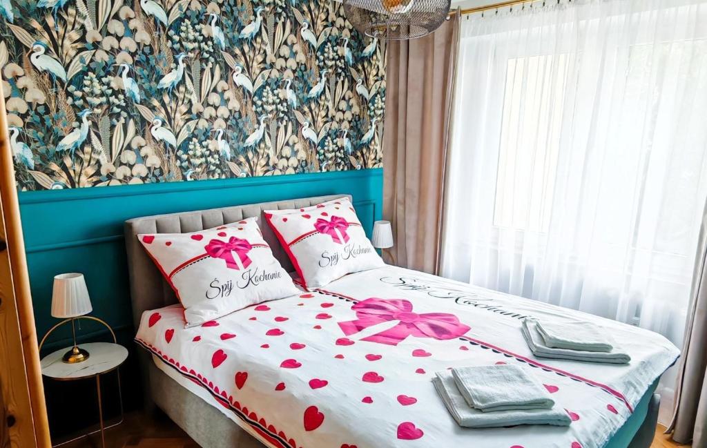 a bed with a pink bow on it in a bedroom at Sen nad Bałtykiem - Apartament z balkonem, Ustka in Ustka
