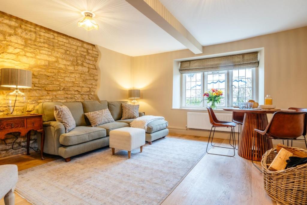 a living room with a couch and a table at Beechwood Cottage | Banham Cottages in Bourton on the Water