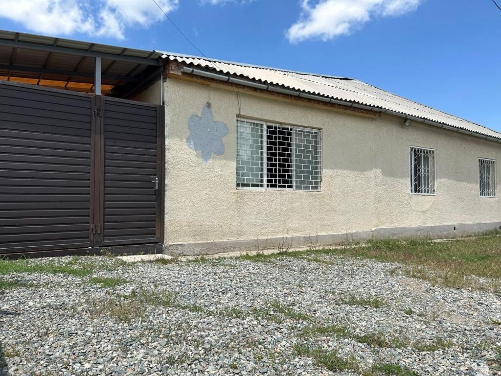 a building with a garage door in front of it at SunHouse Hostel in Karakol