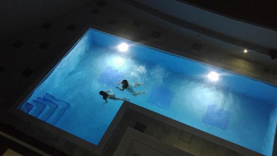 een persoon zwemmen in een groot zwembad bij Luxury in Trogir APARTMANT DRAGO in Trogir