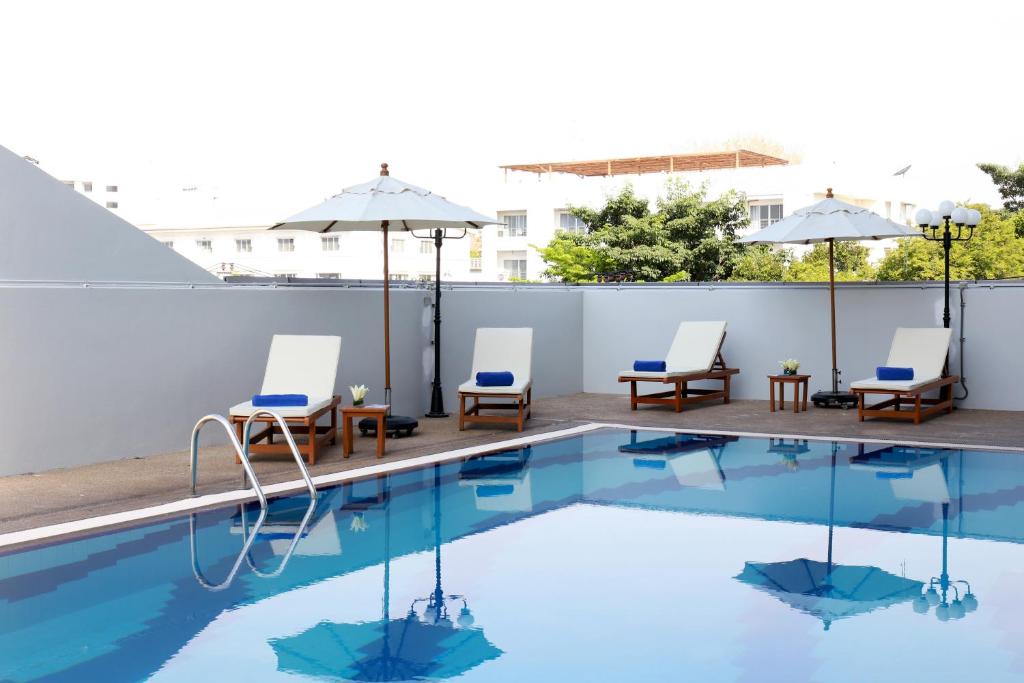 Louis Tavern Hotel في بانكوك: مسبح فيه كراسي ومظلات على مبنى