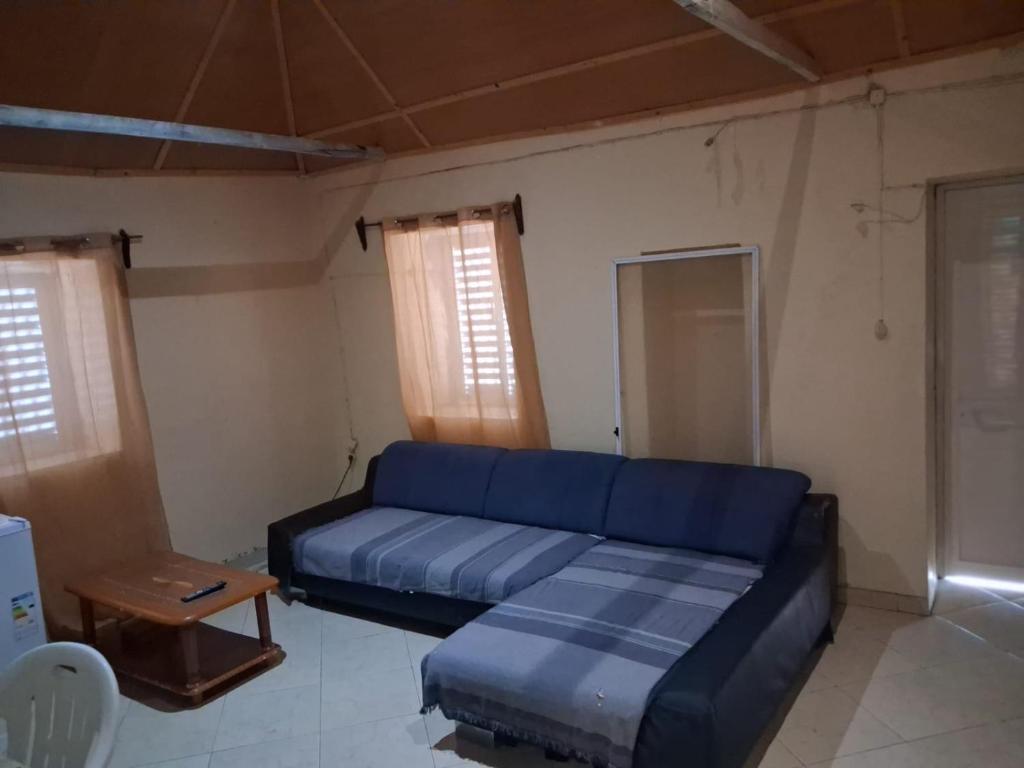 a living room with a blue couch and a table at Porto Calheta in Calheta