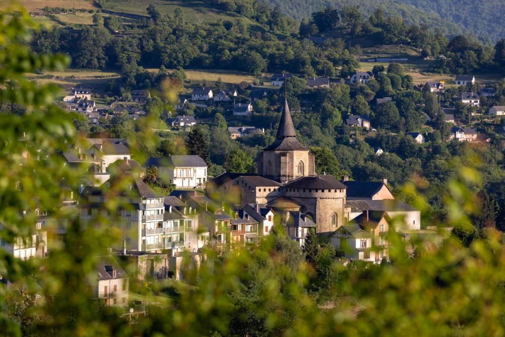 eine kleine Stadt mit einer Kirche und Häusern auf einem Hügel in der Unterkunft Hotel Le Viscos in Saint-Savin