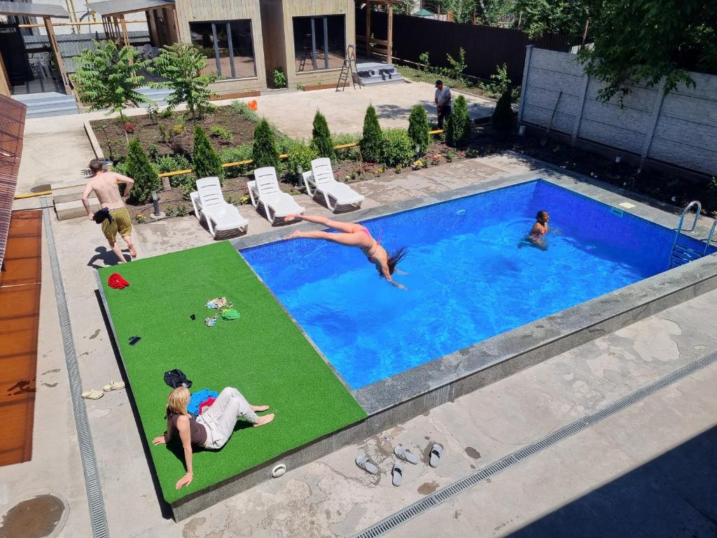 a group of people playing in a swimming pool at Apricot Lodge in Bishkek